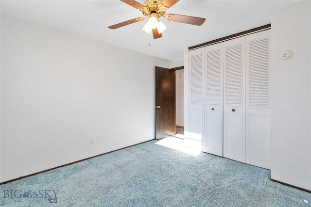 unfurnished bedroom featuring a closet, light colored carpet, ceiling fan, and a textured ceiling