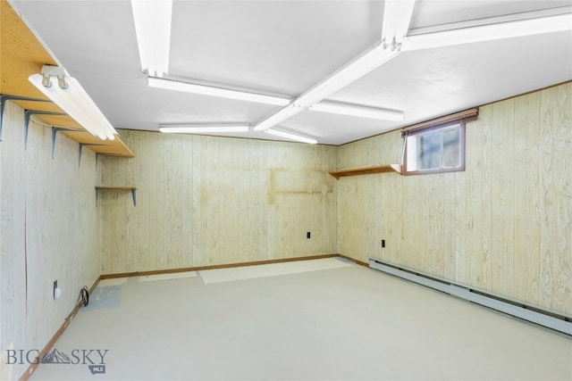 basement featuring a baseboard radiator and wooden walls