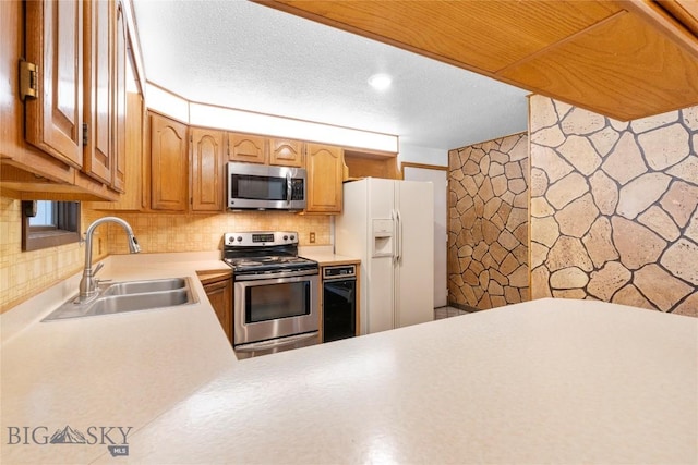 kitchen with stainless steel appliances, light countertops, backsplash, a sink, and a textured ceiling