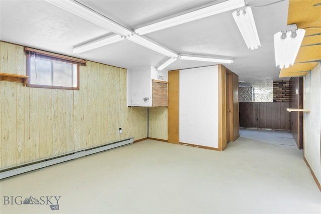 basement featuring wood walls and baseboard heating