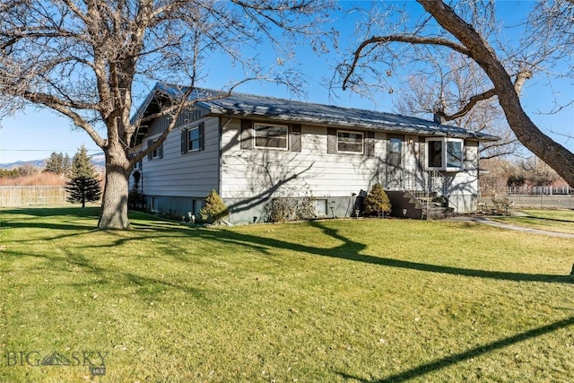 view of home's exterior featuring fence and a lawn