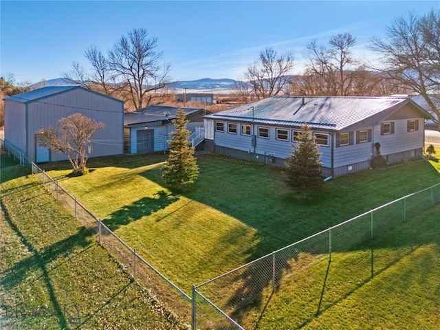 exterior space with fence private yard, a mountain view, metal roof, and a front yard