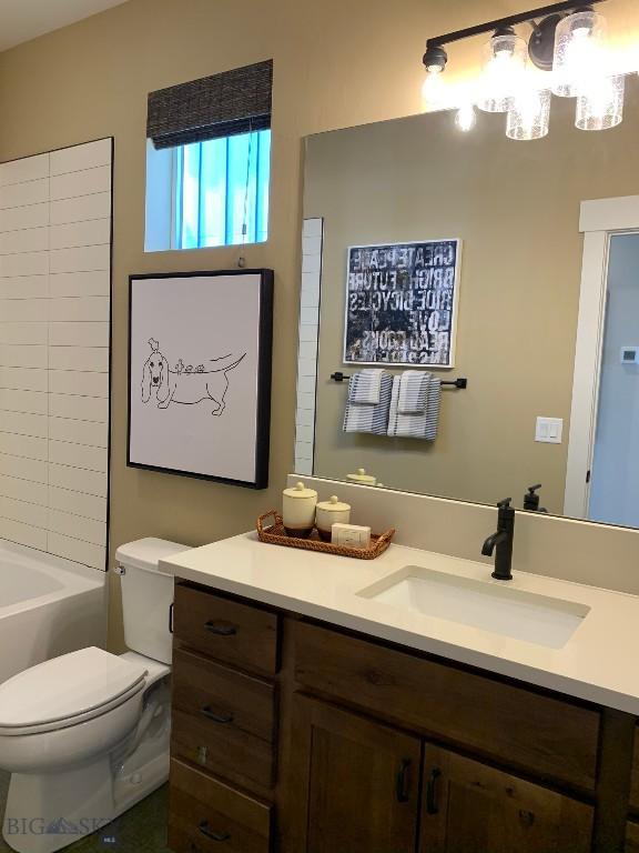 full bathroom featuring vanity, washtub / shower combination, and toilet