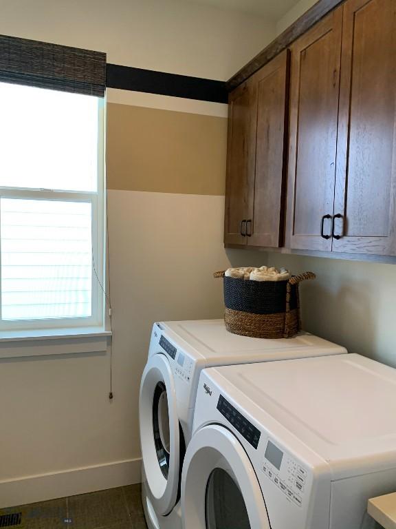 laundry area featuring cabinets and washing machine and dryer