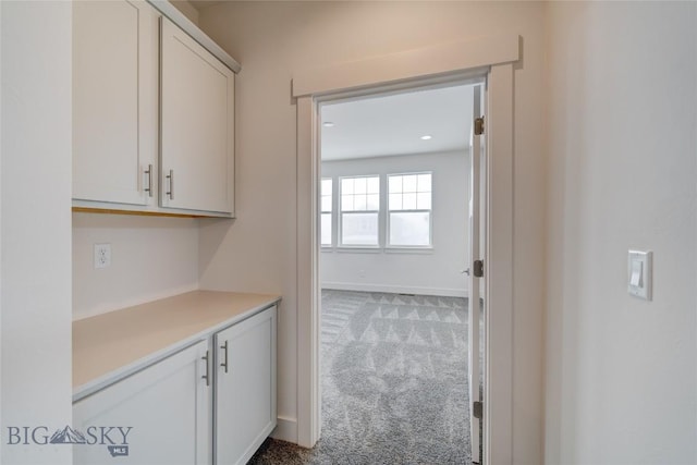 bar featuring carpet flooring and white cabinets