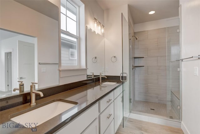 bathroom featuring wood-type flooring, walk in shower, and vanity