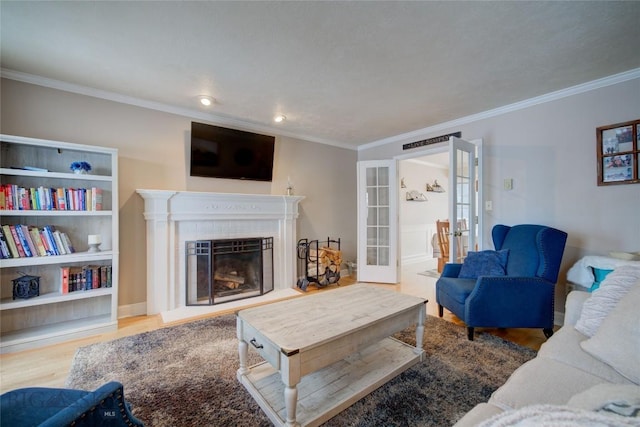 living room featuring french doors, light hardwood / wood-style flooring, a brick fireplace, and crown molding