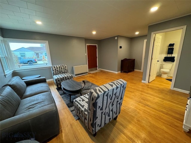 living room with light wood-type flooring and heating unit