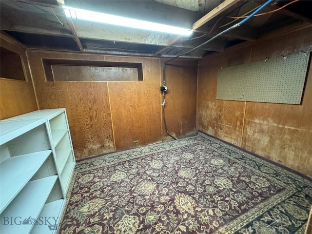 basement featuring wooden walls