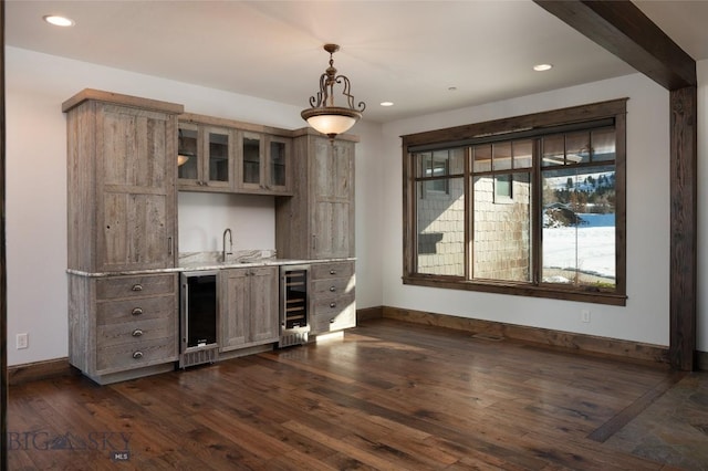 bar with hanging light fixtures, dark hardwood / wood-style flooring, beverage cooler, and sink