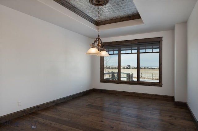 unfurnished room with dark hardwood / wood-style floors and a tray ceiling