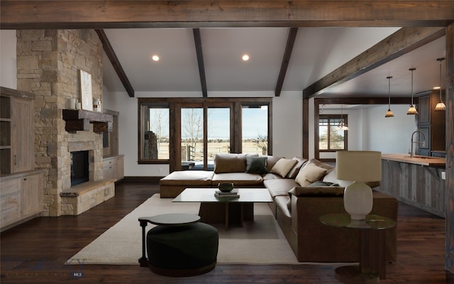 living room with a fireplace, lofted ceiling with beams, dark hardwood / wood-style floors, and a healthy amount of sunlight