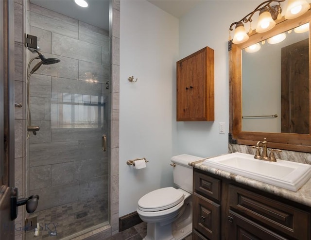 bathroom featuring tile patterned floors, vanity, toilet, and an enclosed shower