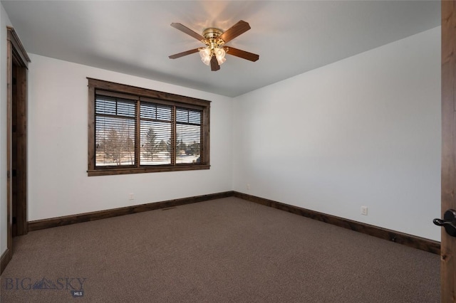 empty room featuring dark colored carpet and ceiling fan