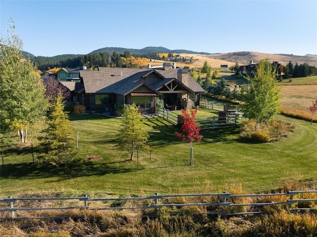 exterior space featuring a mountain view, a front lawn, and a rural view