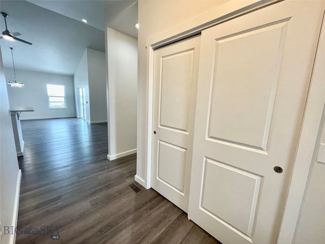 hallway with dark hardwood / wood-style flooring and a notable chandelier