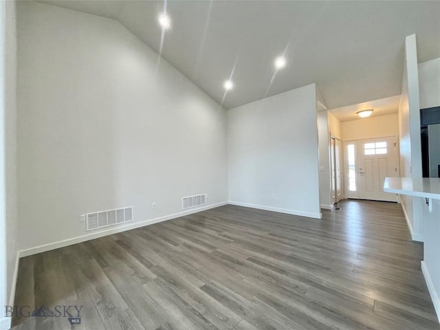 empty room featuring wood-type flooring and lofted ceiling