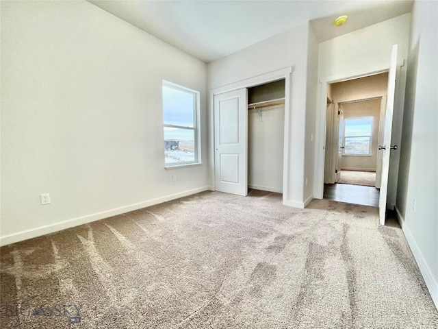 unfurnished bedroom featuring light carpet, a closet, and multiple windows