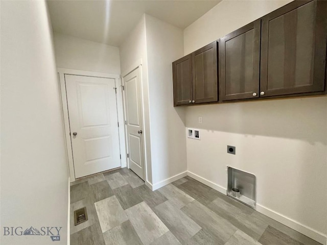 clothes washing area with washer hookup, electric dryer hookup, light hardwood / wood-style floors, and cabinets