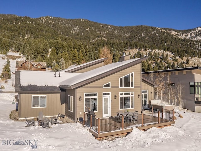 snow covered property featuring a deck with mountain view