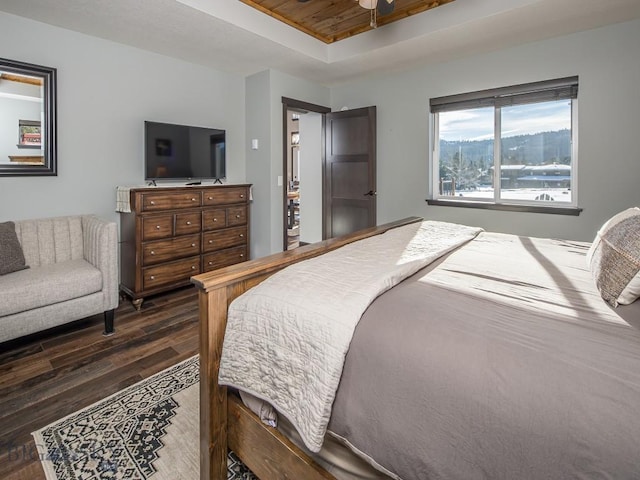 bedroom featuring dark hardwood / wood-style floors and a raised ceiling