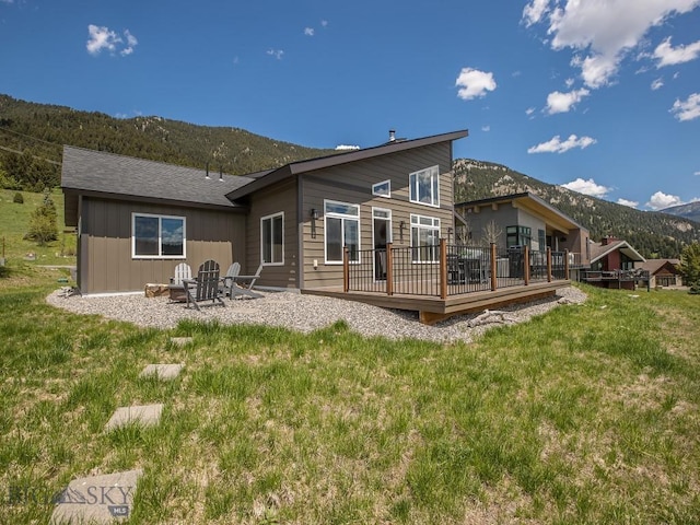 1880 Little Coyote, Big Sky, MT 59716 - rear view of property with a deck with mountain view and a yard