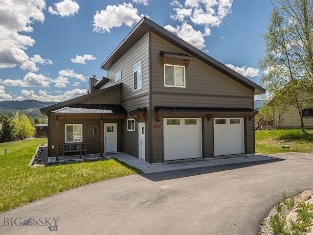 1880 Little Coyote, Big Sky, MT 59716 - view of front of house featuring a standing seam roof, a garage, covered porch, metal roof, and driveway