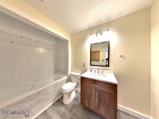 full bathroom with tiled shower / bath combo, wood-type flooring, a textured ceiling, toilet, and vanity