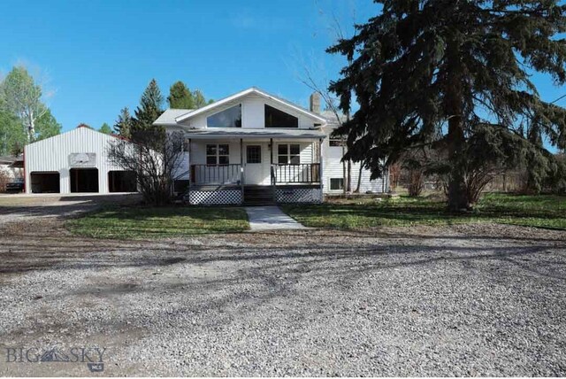 view of front of property featuring covered porch, an outdoor structure, and a garage