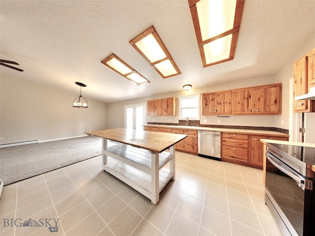 kitchen featuring hanging light fixtures, a textured ceiling, and appliances with stainless steel finishes