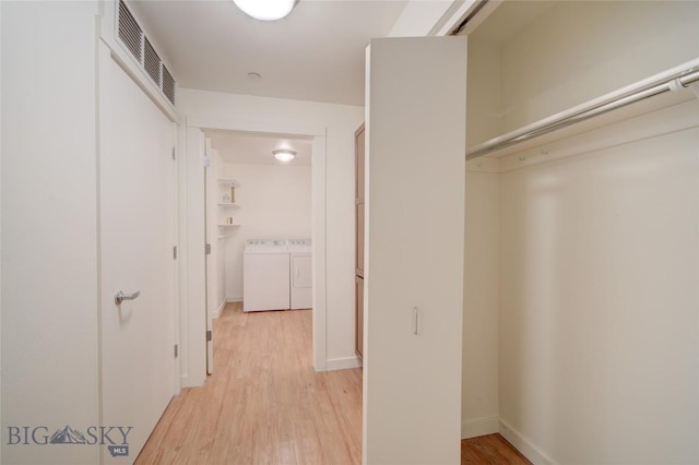 hall featuring independent washer and dryer and light hardwood / wood-style flooring