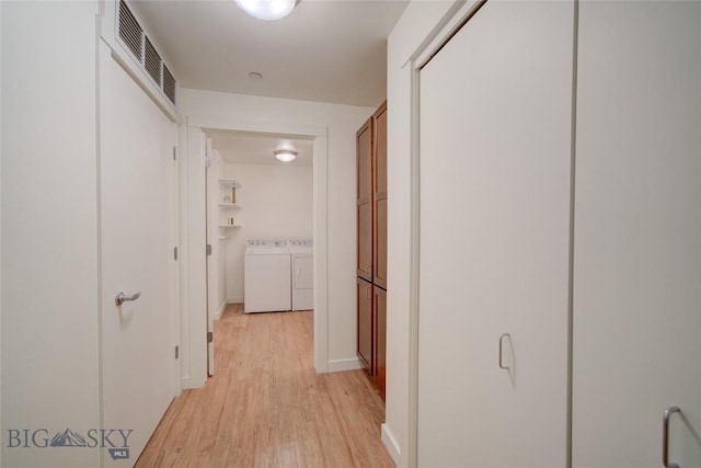 hallway featuring washer and clothes dryer and light wood-type flooring