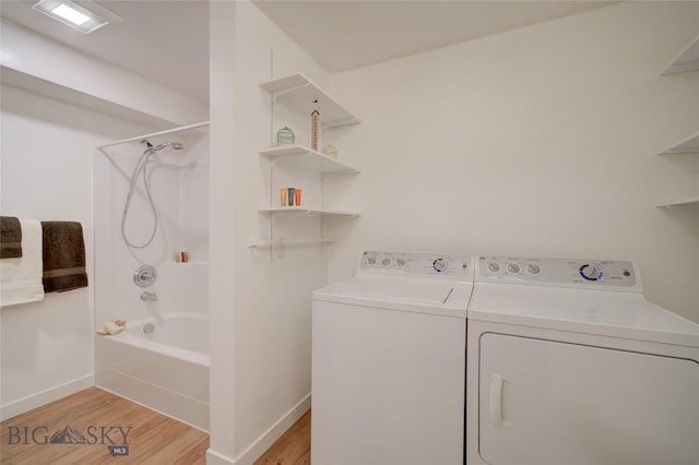 laundry area with light wood-type flooring and separate washer and dryer