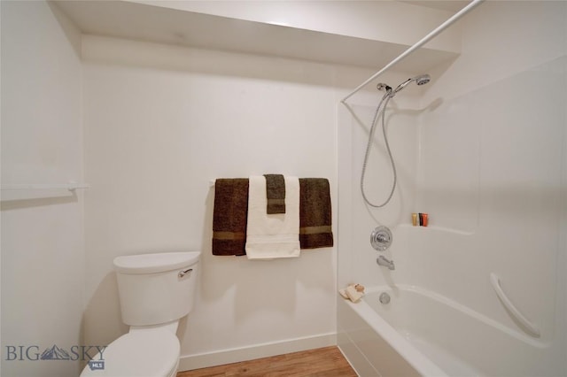 bathroom featuring shower / tub combination, hardwood / wood-style floors, and toilet