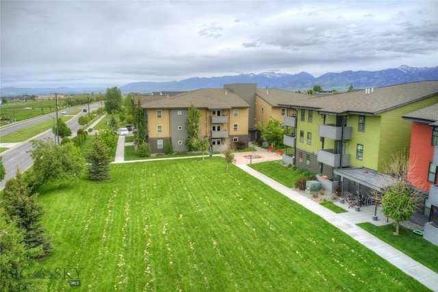 back of property with a lawn and a mountain view