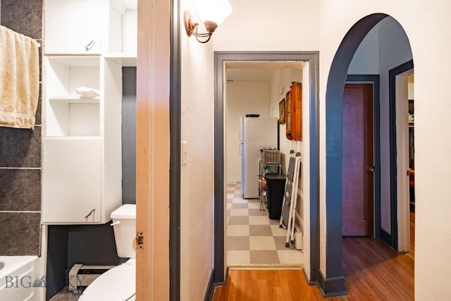 bathroom with hardwood / wood-style flooring and toilet