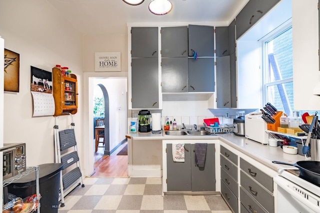 kitchen with white range oven, gray cabinetry, and sink