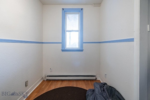 unfurnished room featuring light hardwood / wood-style floors and baseboard heating