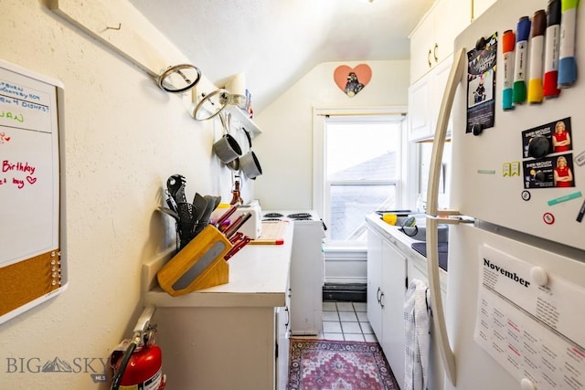 laundry area with cabinets, independent washer and dryer, and light tile patterned floors