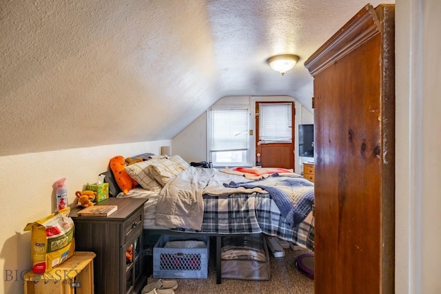 carpeted bedroom featuring a textured ceiling and vaulted ceiling