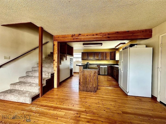 kitchen with dishwasher, a center island, white fridge with ice dispenser, light hardwood / wood-style floors, and a textured ceiling