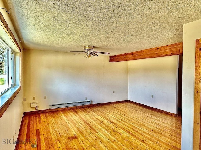 empty room featuring ceiling fan, light wood-type flooring, a textured ceiling, and a baseboard radiator