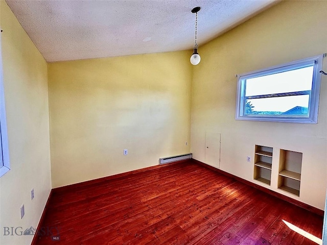 spare room featuring dark hardwood / wood-style floors, a baseboard heating unit, a textured ceiling, and vaulted ceiling