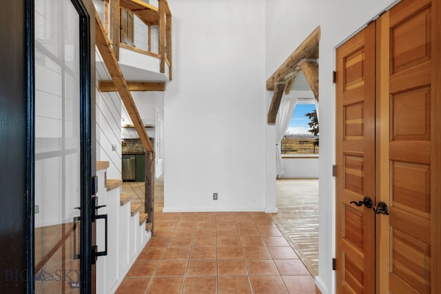 foyer with a towering ceiling and light tile patterned flooring