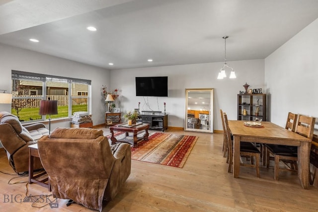 living room with light hardwood / wood-style floors and an inviting chandelier