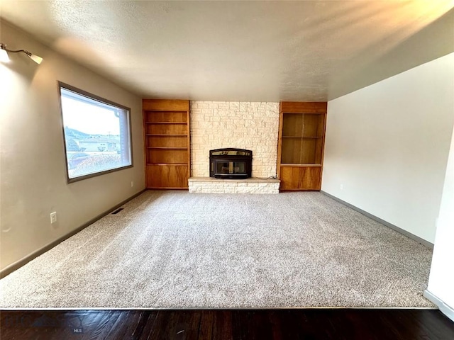 unfurnished living room with carpet flooring, built in features, and a fireplace