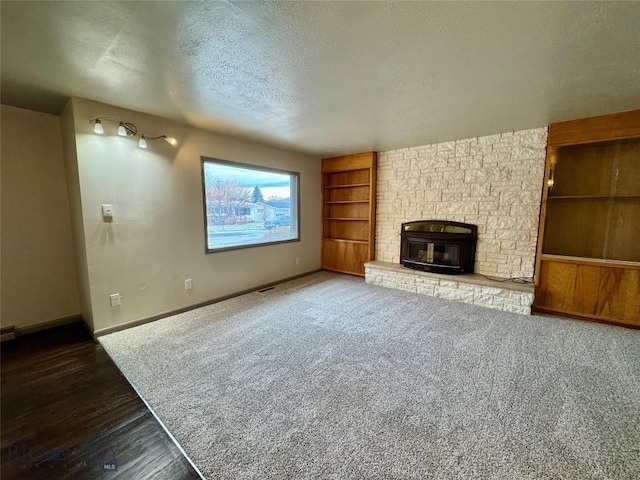 unfurnished living room with a fireplace, carpet, and a textured ceiling