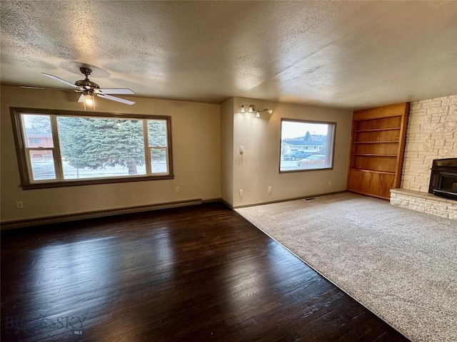 unfurnished living room featuring a textured ceiling, dark hardwood / wood-style floors, ceiling fan, and a baseboard heating unit