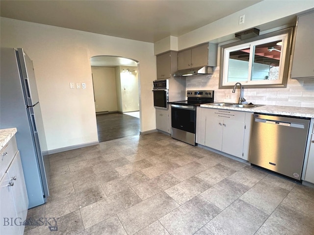 kitchen with backsplash, gray cabinetry, sink, and appliances with stainless steel finishes