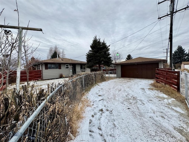 snowy yard with a garage and an outdoor structure